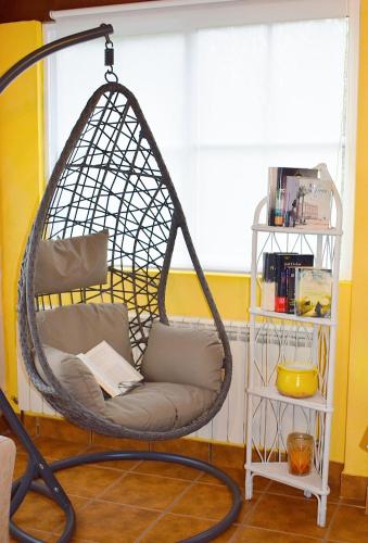 a hanging hammock chair in a room with a window at A Beira da Cortella in Melón