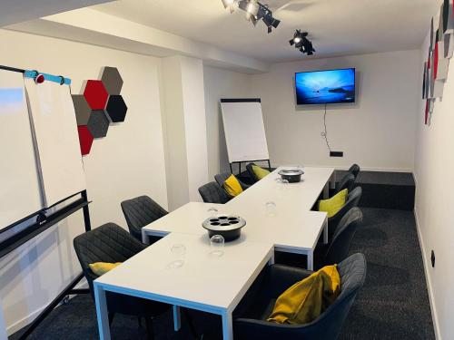 a conference room with tables and chairs and a tv at Berghotel Kristall in Idar-Oberstein