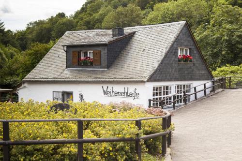 a small white building with flowers in the window at Berghotel Kristall in Idar-Oberstein