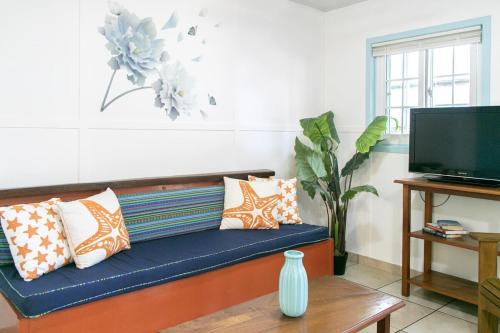 a living room with a blue couch with pillows at Candyland Vacation Rentals in Bocas del Toro
