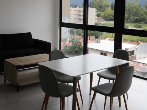 a table and chairs in a room with a window at Departamentos Ciudad de Nieva in San Salvador de Jujuy