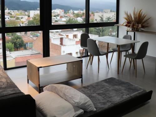 a living room with a table and a large window at Departamentos Ciudad de Nieva in San Salvador de Jujuy