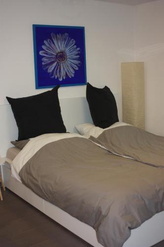 uma cama com duas almofadas e um quadro na parede em Ferienwohnung Im Weihergrund em Engen