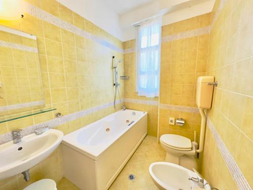 a bathroom with a tub and a toilet and a sink at Residence & Suites in Bellaria-Igea Marina