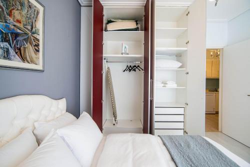 a bedroom with a white bed and a closet at Beachfront ZEN sea view apartment in Itea