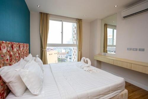 Grande Caribbean - 1 BR Apartment, 8th Floor #A815 في جنوب باتايا: غرفة نوم بها سرير أبيض كبير مع نافذة