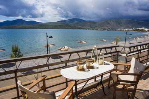 a table and chairs on a balcony with a view of the water at Beachfront ZEN sea view apartment in Itea
