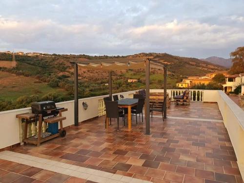 a patio with a table and a grill on a roof at Casa Pellegrino in Solità