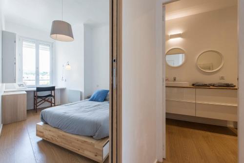 - une chambre avec un lit, un lavabo et un miroir dans l'établissement Vue Golfe St Tropez à Ste Maxime YourHostHelper, à Sainte-Maxime