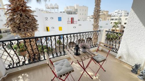 a balcony with two chairs and a table on it at Hills 2bdr Seaside Makenzy Larnaka in Larnaka