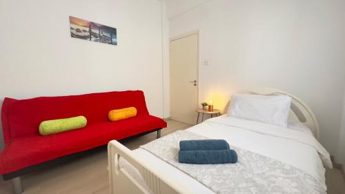 a red couch and a red bed in a room at Hills 2bdr Seaside Makenzy Larnaka in Larnaka