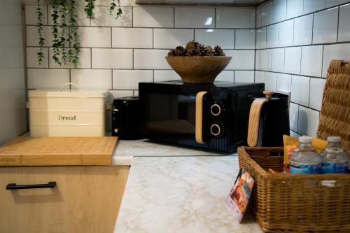 a kitchen counter with a microwave and a bowl on top at Luxury seaside getaway Whitley Bay in Whitley Bay