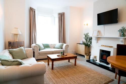 a living room with two couches and a fireplace at Luxury seaside getaway Whitley Bay in Whitley Bay