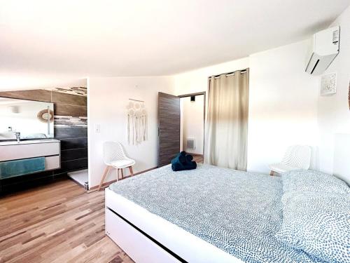 une chambre blanche avec un lit et une cuisine dans l'établissement MAGNIFIQUE, GRAND ET MODERNE T3, PISCINE, WIFI, CLIM, VUE ET EMPLACEMENT SUPERBES, Coudalère, au Barcarès