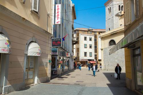 a group of people walking down a street with buildings at Hostel Kosy in Rijeka