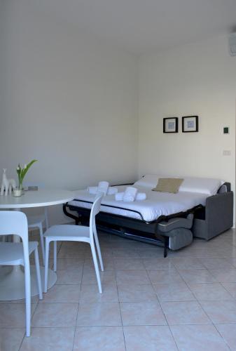 a bed in a room with a table and chairs at Poggio Al Lago Apartments & Rooms in Sirmione
