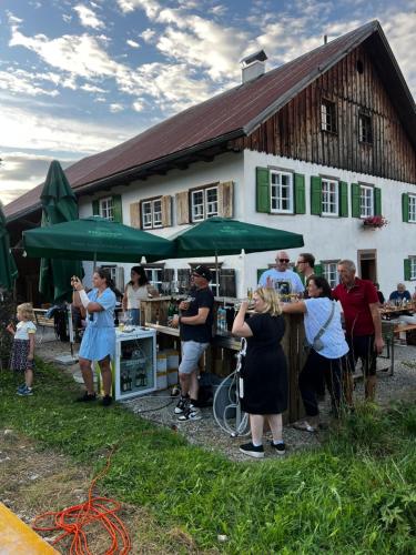 a group of people standing in front of a building at Floras Haus Hostel in Schattwald
