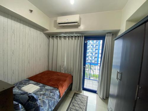 a small bedroom with a bed and a window at LIAM's Staycation in Manila