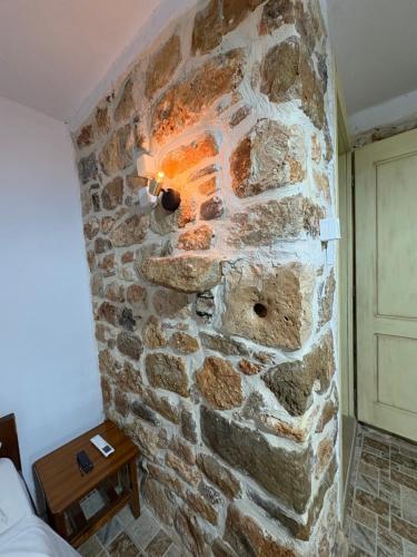 a stone fireplace in the corner of a room at Traditional house Nikos in Roussokhória