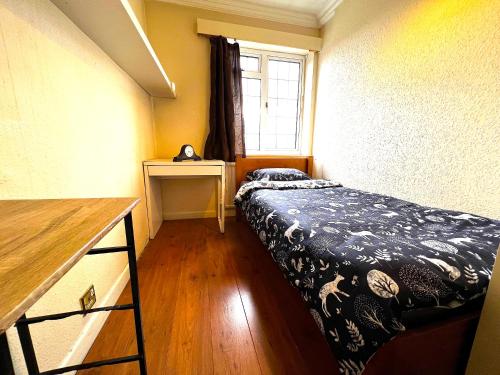 a small bedroom with a bed and a window at Thornton Heath in Thornton Heath