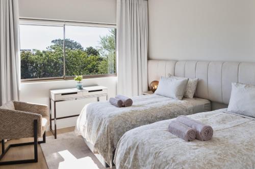 a bedroom with two beds and a window at Luxurious 1 bedroom in Camps Bay villa with a pool in Cape Town