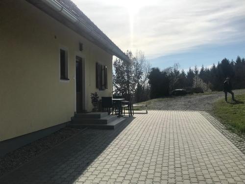 a man standing outside of a building with a table at Ferienhaus Neuhold in Kitzeck im Sausal