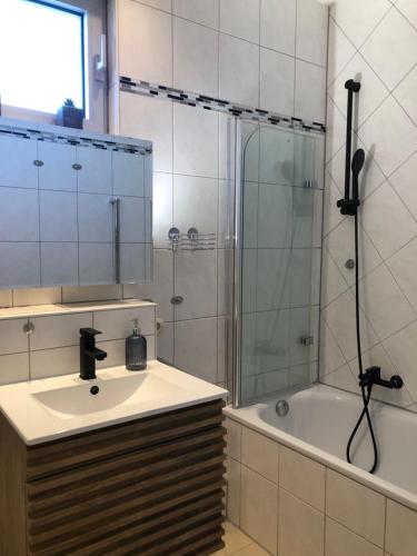 a bathroom with a sink and a shower and a tub at Tiny Atelier Leihfahrräder Gratis Shuttleservice in Bad Harzburg