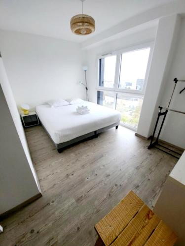 une chambre blanche avec un lit et une grande fenêtre dans l'établissement De Monzie 6pers Tv Wifi 2, à Nantes