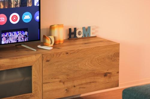 a tv sitting on top of a wooden entertainment center at SanPietro Vacation Apartments in Durrës