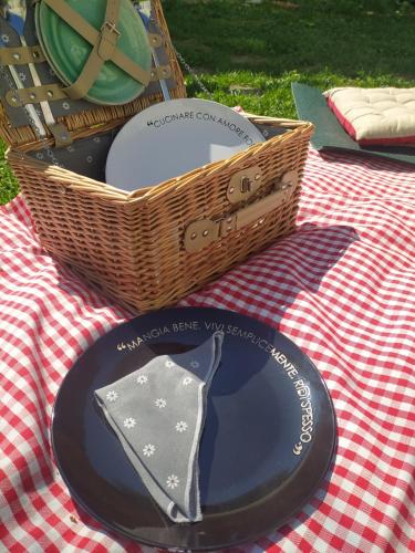 a picnic table with a basket and a plate with a tie at La casa nel Monferrato "LA CONTENTËSSA" in Asti