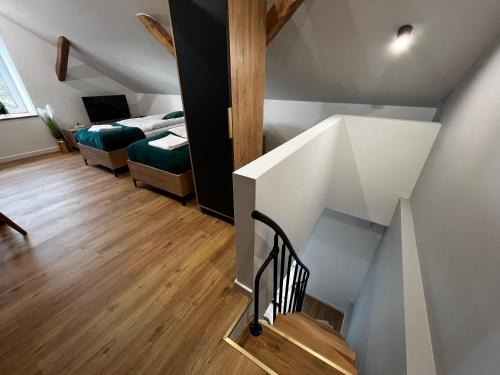 a staircase in a room with a bedroom and a bed at Do Brzegu Lepiej - Siedlisko Jemiołowo - Apartamenty Blisko Jeziora II in Olsztynek