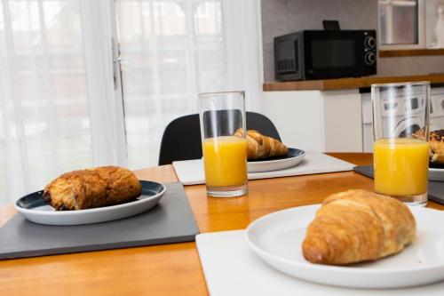 a table with two plates of food and two glasses of orange juice at Primrose lodge cosy 2 bedroom house in a quiet in Norwich