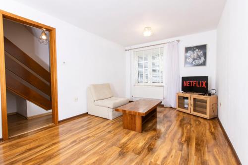 a living room with a table and a chair at Primrose lodge cosy 2 bedroom house in a quiet in Norwich