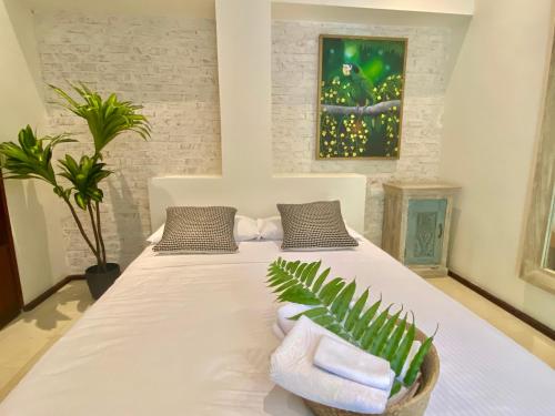 a bedroom with a bed with towels and a plant at Boutique Hotel Casa Grande, Parrot's Paradise Suite in Santo Domingo