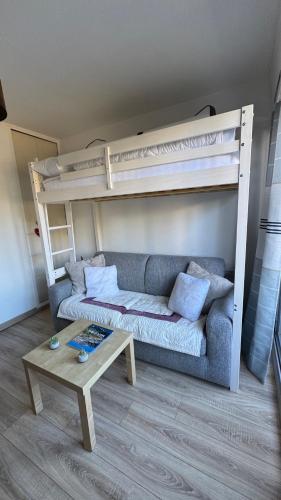 - un salon avec un canapé et des lits superposés dans l'établissement Charmant studio au cœur d Auron 119, à Auron