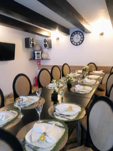 a long table with chairs and a clock on the wall at Pension Casablanca in Campina