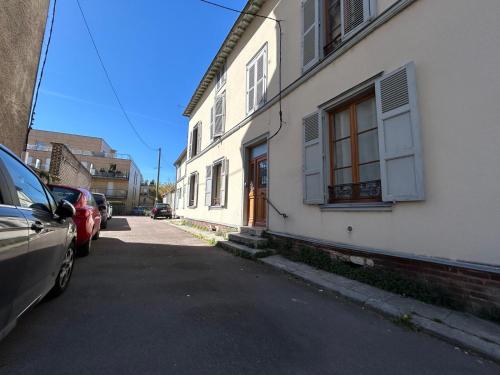 une rue avec des voitures garées à côté d'un bâtiment blanc dans l'établissement La Preize station - Théatre de Champagne - Wifi, à Troyes