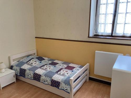 a bedroom with a bed with a quilt on it at Longère du ruisseau in Armes
