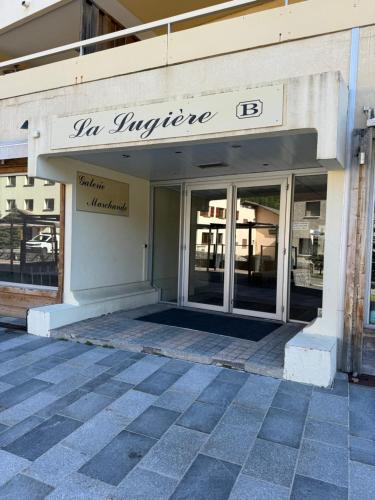 une entrée à un bâtiment avec un panneau sur celui-ci dans l'établissement Charmant studio au cœur d Auron 119, à Auron