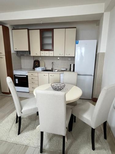 a kitchen with a table and chairs and a refrigerator at Gabi's Cozy Corner in Kumanovo