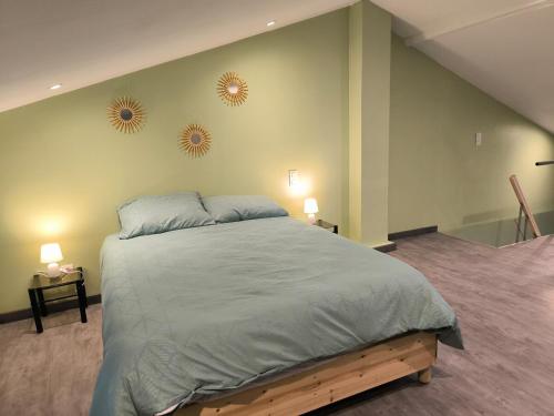 - une chambre avec un grand lit et deux miroirs sur le mur dans l'établissement Charmante maison de village, à Suze-la-Rousse