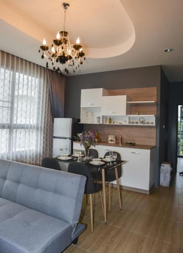 a kitchen and living room with a table and a chandelier at OHDEE Hostel Chiangmai in Chiang Mai
