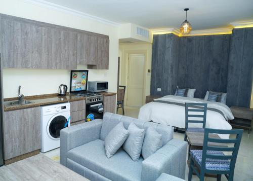 a living room with a bed and a blue couch at Gardens Complex in Amman