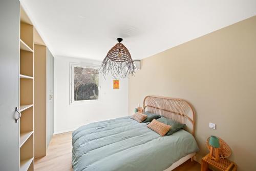 une chambre avec un lit et un lustre dans l'établissement Villa Moderne avec Piscine Privée, à La Crau