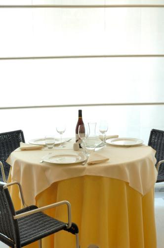 a yellow table with wine glasses and a bottle on it at Hotel Le Roi in Varazze