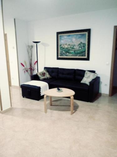a living room with a black couch and a coffee table at ODELOT Toledo in Olías del Rey