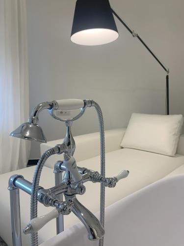 a lamp sitting next to a bed with a couch at Eveline 2 - Piscina Privata o Jacuzzi in Sanremo