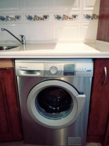 a kitchen with a washing machine under a counter at ODELOT Toledo in Olías del Rey