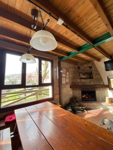 a large wooden table in a room with a fireplace at Albergue Peña Castil in Sotres