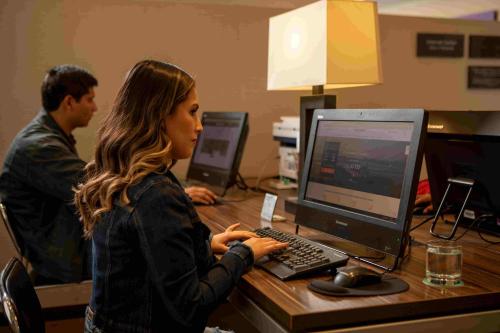 a woman sitting at a desk with a computer at Casa Andina Select Tacna in Tacna